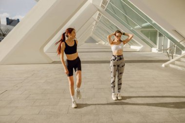 İki genç bayan sporcu sabah koşusundan sonra dinleniyor. Yüksek kalite fotoğraf