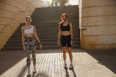 İki genç bayan sporcu sabah koşusundan sonra dinleniyor. Yüksek kalite fotoğraf