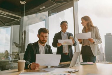 İş adamları modern ofis içinde proje stratejileri hakkında anlamlı tartışmalara girişirler.