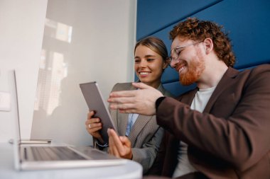 İki hevesli profesyonel, çağdaş bir çalışma alanında dijital cihazlar kullanırken üretken bir anı paylaşıyor