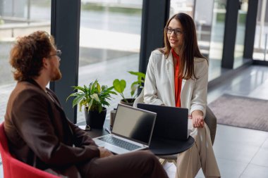Modern bir ofis ortamında, iki profesyonel, çalışmaları hakkında derin bir tartışmaya girişirler.