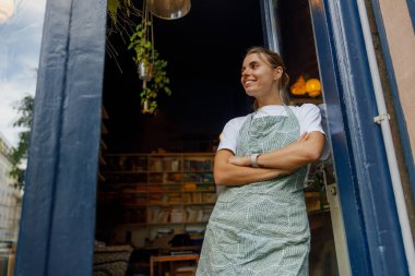 Neşeli ve misafirperver bir barista, tüm müşterileri davetkar titreşimlerle dolu, güneşli bir kafede karşılar.