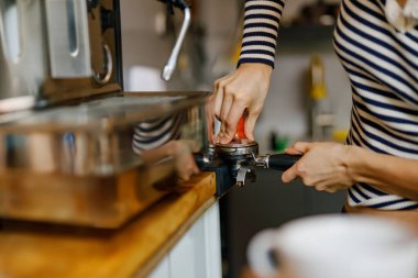 Yetenekli ve yetenekli bir barista nefis bir kahve makinesi hazırlamak için ustaca bir espresso makinesi kullanıyor.