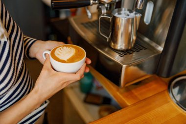 Yetenekli bir barista, kahve sanatında uzmanlığını sergileyerek güzel bir latte hazırlar.