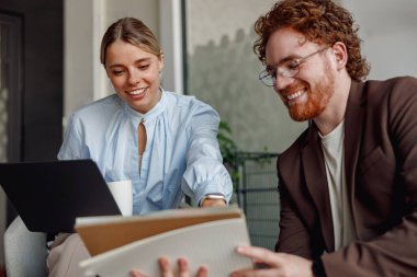 Çağdaş bir ofis ortamında, iki yetenekli profesyonel dizüstü bilgisayar kullanarak fikirlerle ilgili bir tartışmaya girişiyor.