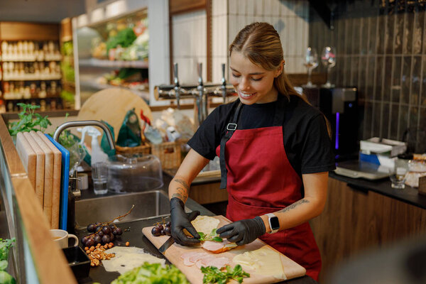 A young, talented chef expertly chopping a variety of fresh vegetables in a vibrant, modern kitchen setting