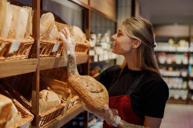 Son derece yetenekli bir fırıncı, canlı ve modern bir fırın ortamında taze ekmek topluyor.
