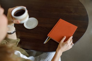 Güzel, huzurlu bir an, sıcak bir fincan kahveyi, kırsal bir ahşap masada duran bir günlüğün yanında yakalıyor.