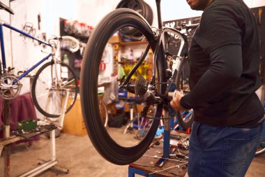 Bisiklet atölyesinde çalışan profesyonel erkek tamirci. Bisiklet servisi, tamir ve geliştirme