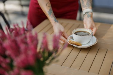 A serene moment with a steaming coffee cup on a decorated table, surrounded by vibrant blooming flowers clipart