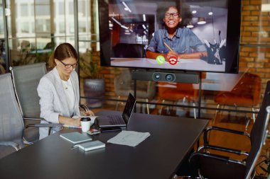 Şık bir ofis ortamında kadın video konferansı düzenleyen profesyonel bir sanal toplantı.