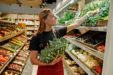 Kendini işine adamış ve profesyonel bir medya stokçusu canlı bir market ortamında taze sebzeleri ustalıkla organize eder.