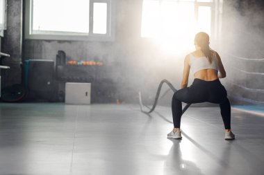 Bir atlet sıkı bir dövüş halatları çalışmasıyla meşgul, inanılmaz bir güç ve sarsılmaz bir kararlılık sergiliyor.