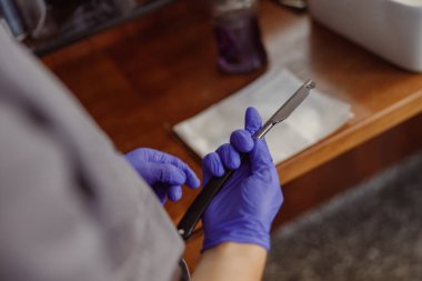 Eldivenli ellerin dikkatlice tutulduğu ve titiz bir iş için tasarlanmış profesyonel bir aletin kullanıldığı yakın çekim görüntüsü