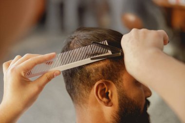 Yetenekli bir berbere yakın plan saç kesme, etkileyici ve şık bir bakım seansı.