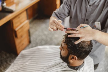 Geleneksel bir berber dükkanında ustalıkla saç stili yapan yetenekli bir berber, her detaya dikkatle odaklanıyor.