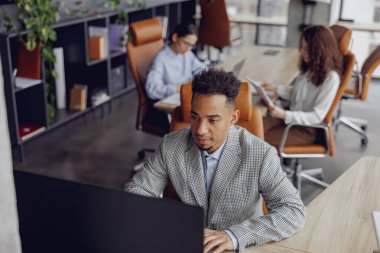 Modern, yaratıcı ve üretken bir çevrede projeler üzerinde çalışan profesyonellerle dolu enerjik bir ofis sahnesi.