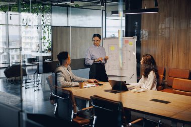 Kendini adamış bir takım, yenilikçi fikirler ve stratejileri tartışmak için şık bir konferans salonunda işbirliği yapıyor.