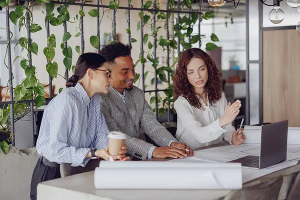 Profesyoneller canlı yeşil bir çalışma alanında stratejik planlar üzerinde tartışarak işbirliği ve yaratıcılığı teşvik ediyorlar