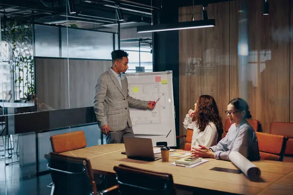 Parlak, modern bir ofis içinde strateji üzerine anlamlı tartışmalara giren çeşitli bir grup.