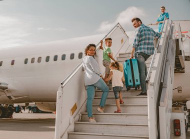 Neşeli bir aile, yaklaşan seyahat maceraları için heyecan ve heyecanla dolu bir uçağa biniyor.