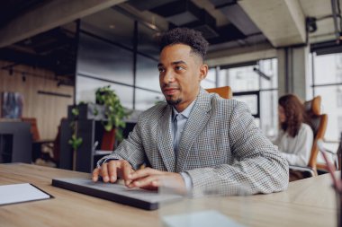 Modern bir ofis alanında özenle çalışan, profesyonelliği ve üretkenliği somutlaştıran odaklanmış bir birey
