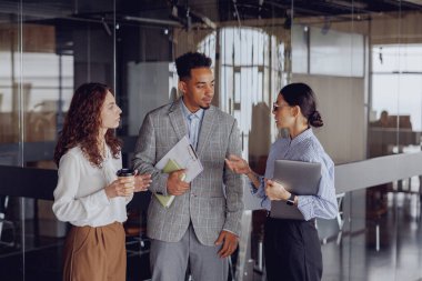 Üç yetenekli profesyonel, şık ve modern bir ofis içinde işbirlikçi ve dinamik bir tartışmaya giriştiler.