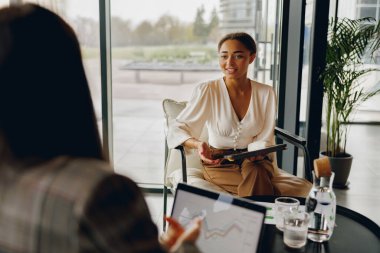 İki deneyimli profesyonel, şık ve modern ofis ortamında oldukça verimli bir toplantıya katılıyor.