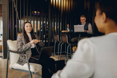 Bir grup profesyonel modern bir ofis içinde anlayışlı ve üretken bir tartışmaya girişiyor.