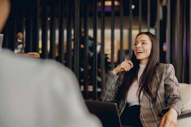 Kendine güvenen bir kadın, profesyonelliği vurgulayan modern bir ofisi ön plana çıkaran önemli bir iş toplantısına katılır.