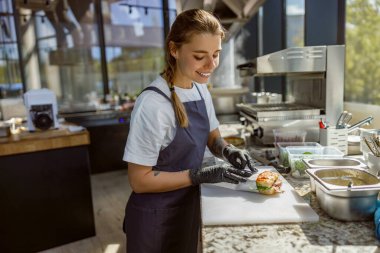 Yetenekli genç bir şef modern ve çağdaş bir mutfak ortamında nefis bir taze yemek hazırlıyor.