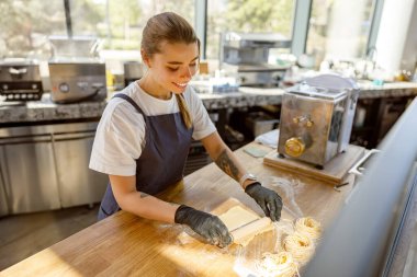 Yetenekli bir fırıncı, yaratıcılığı teşvik eden modern ve iyi aydınlatılmış bir mutfakta çeşitli lezzetli hamur işleri yapar.