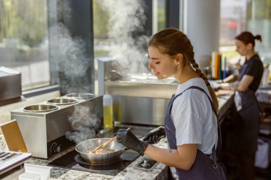 Yetenekli bir şef, canlı ve modern bir mutfakta mükemmel yemekler hazırlar. Gerçek aşçılık sanatını sergiler.