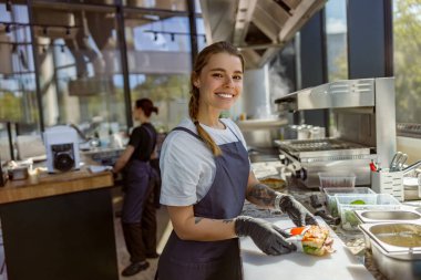 Neşeli ve yetenekli bir şef şık bir restoran mutfağında taze ve canlı malzemeler hazırlar.