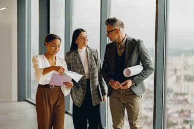 Yetenekli bir ekip proje detaylarını yaratıcılığı ve işbirliğini destekleyen modern bir ofiste tartışır.