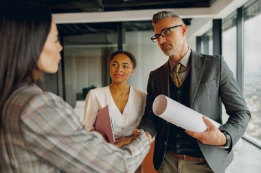 Şık bir ofiste kendini işine adamış bir ekip planlarını tartışıyor, profesyonellik ve işbirliği sergiliyor.