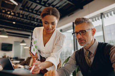 Bir grup profesyonel şık ofis ortamında yenilikçi fikirler hakkında anlamlı tartışmalara giriyorlar.