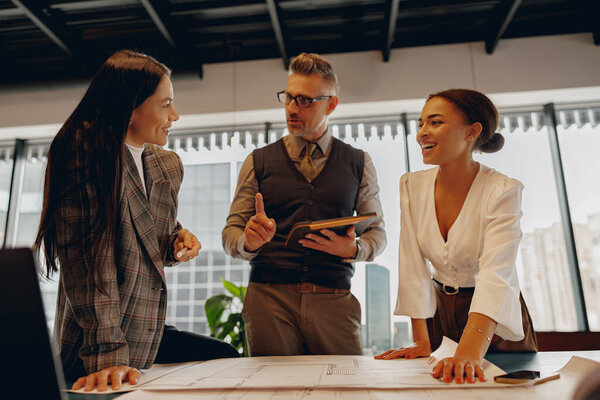 Professionals are actively engaging in a collaborative discussion within a stylish and modern office environment