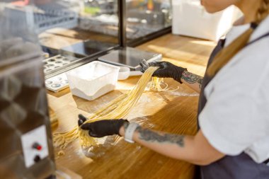 Çok yetenekli ve yetenekli bir şef modern, çağdaş bir mutfakta lezzetli, taze makarna hazırlar.