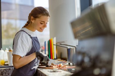Yetenekli bir barista, parlak ve çağdaş bir kafede taze ürünleri dilimler.