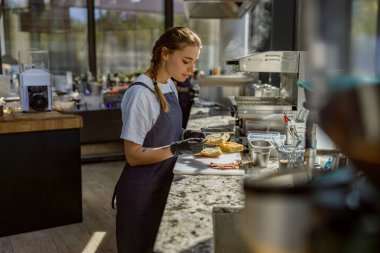 Son derece odaklanmış ve yetenekli bir şef modern bir mutfakta ustalıkla mükemmel bir gurme tabağı hazırlıyor.