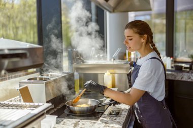 Çok yetenekli bir aşçı, modern ve güzel bir mutfakta çok lezzetli bir yemek hazırlıyor.