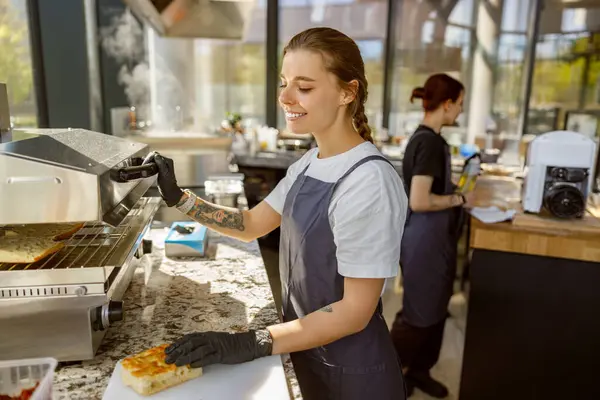 Baristaların ustalıkla lezzetli yemekler ürettiği canlı bir kafe ortamı.