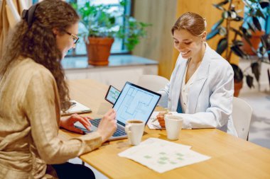 Bir hasta ve bir doktor, daha iyi referans için dizüstü bilgisayar ve çeşitli belgeler aracılığıyla sağlık konularında işbirliği yaparlar.