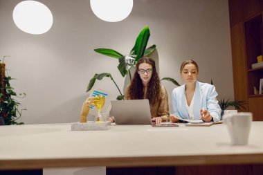 Bitkilerin ve teknolojinin olduğu modern bir ofiste, iki kadın fikirlerini desteklemek için düşünceli bir tartışmaya girişirler.