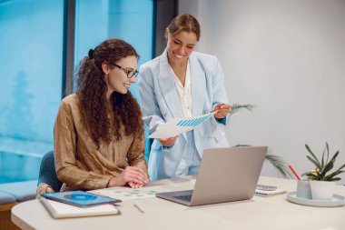 İki profesyonel yenilikçi fikirleri tartışırken ve paylaşırken dinamik ve modern bir çalışma alanında işbirliği yapıyorlar.