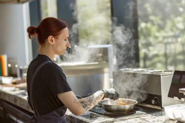 Tutkulu bir aşçı ustalıkla şık bir mutfakta lezzetli yemekler hazırlar ve mutfak sanatını sergiler.