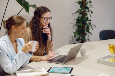 İki yetenekli profesyonel, şık bir çalışma alanında ileri teknoloji kullanarak verimli bir toplantı düzenliyor.