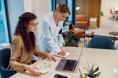 Modern ofis ortamında, iki yetenekli profesyonel birlikte dinamik ve yaratıcı tartışmalara giriyorlar.