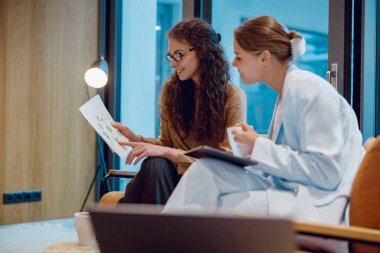 Sıcak bir ofiste, iki yetenekli profesyonel proje içgörüleri hakkında verimli bir tartışma yapıyorlar.